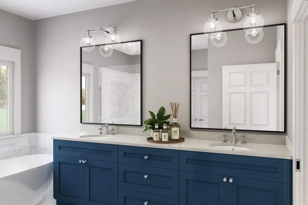 A primary bath with a navy double vanity and round mirrors