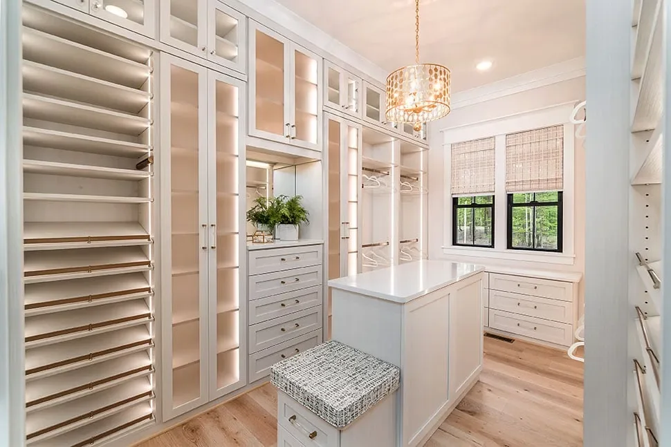 A walk-in closet with lit shelving and a center island