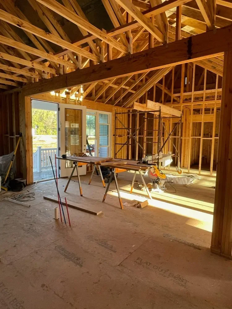 Framed great room with afternoon light pouring through the window openings