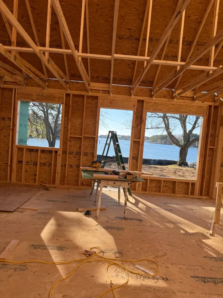 A framed room with window openings looking out at the water