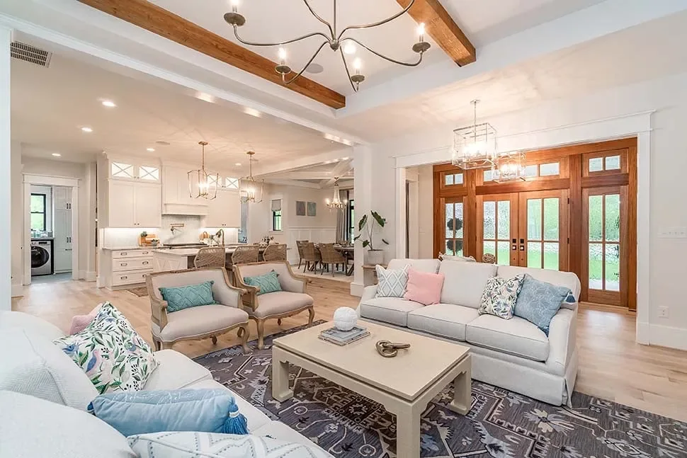 A bright living room with exposed beams, white sofas and French doors