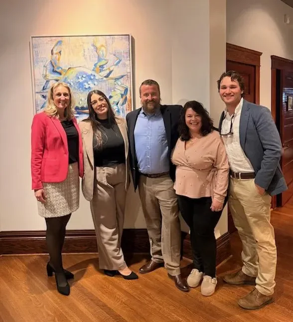The Legasea team together in the office, in front of a blue crab painting