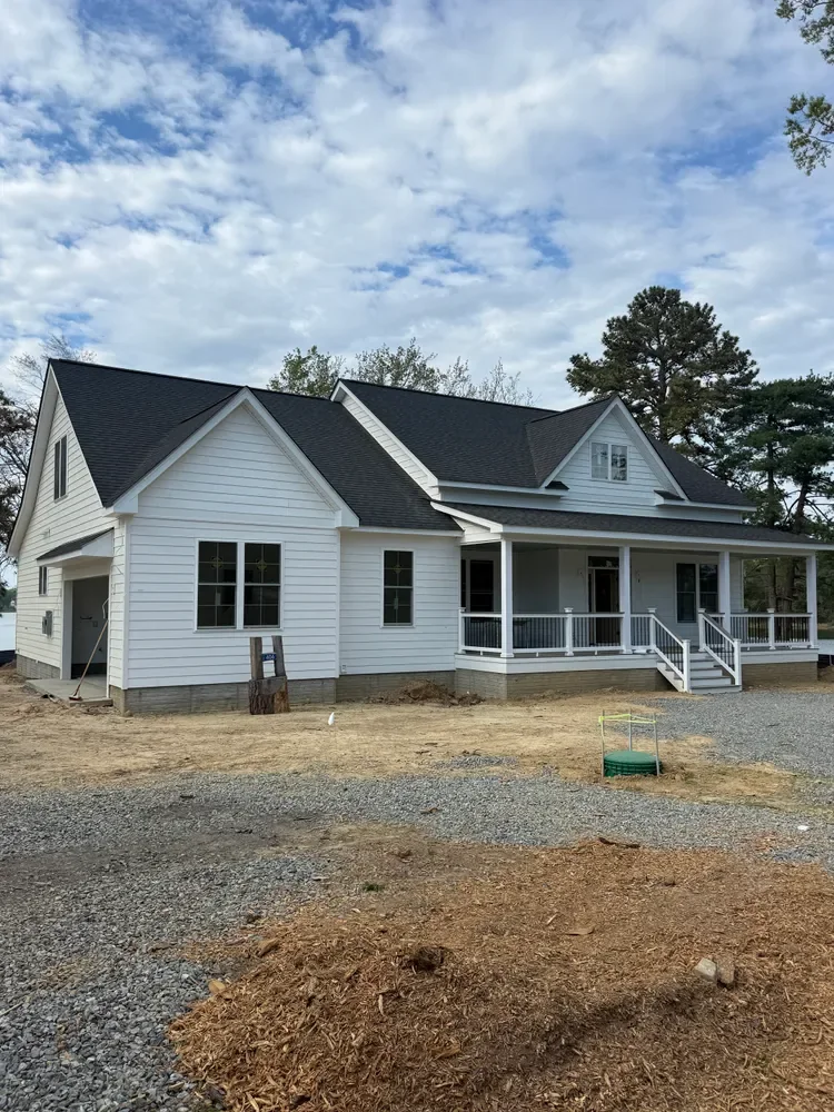A finished white Legasea farmhouse with a covered front porch
